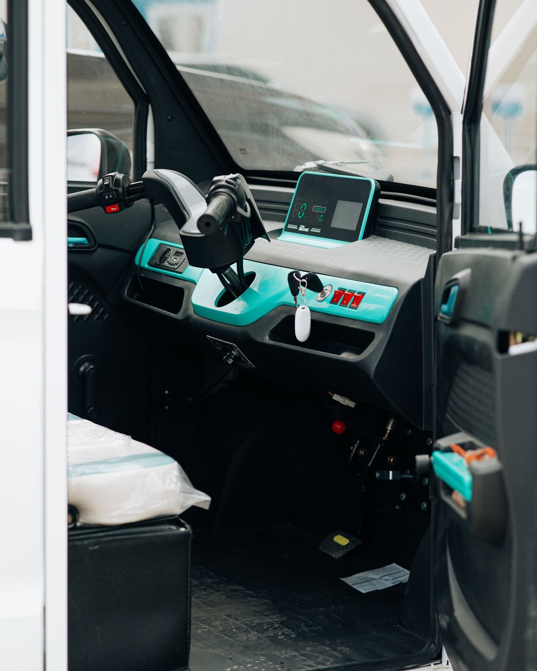 Wide interior view of a Mobility Ventures vehicle cabin showing the driver's seat and teal dashboard.